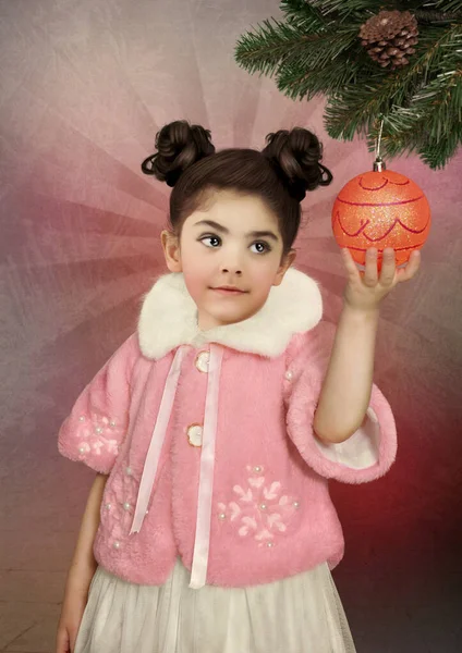 Dziewczynka Różowym Futrze Trzyma Ręku Świąteczną Piłkę — Zdjęcie stockowe