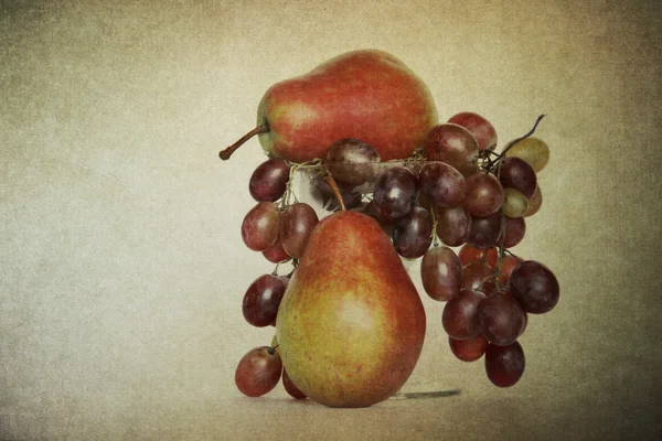 Pears and grapes in glass vase — Stock Photo, Image