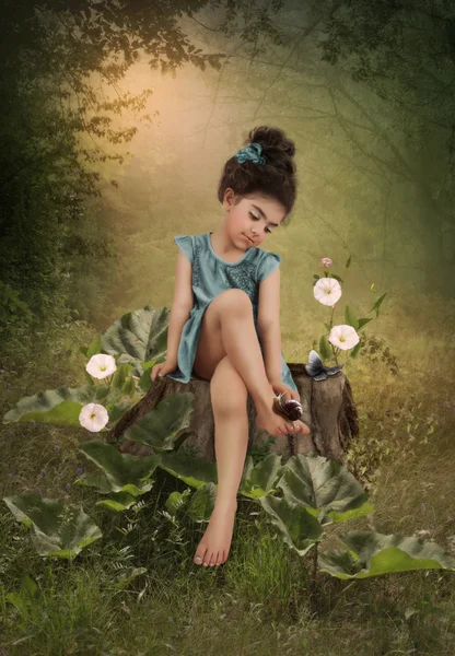 Little girl looks at snail on leg — Stock Photo, Image