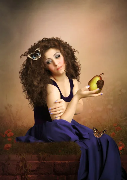 Girl with curly hair holding pear — Stock Photo, Image