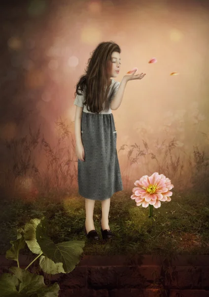Kleines Mädchen bläst auf Blütenblättern — Stockfoto
