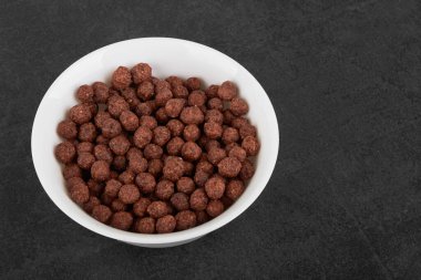 Siyah bir taş yüzeyde çikolata taneleri.