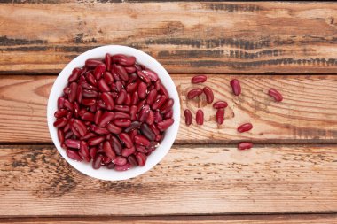 Ahşap arka planda izole edilmiş kırmızı fasulyeler.