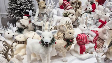 Mağazada bir sürü Noel kardan adam ve oyuncak bebek var..