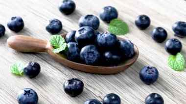 Ahşap bir kasede yaban mersini, tek tek ahşap bir arka planda..