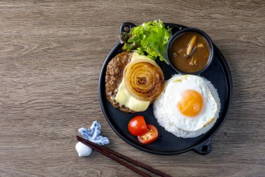 Loco Moco, geleneksel bir Hawaii yemeği olan teriyaki aromalı biftek köftesi ve pirinç yatağında kızarmış yumurta.