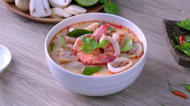 Karides Tom Yum Tahta bir masada beyaz bir kase içinde