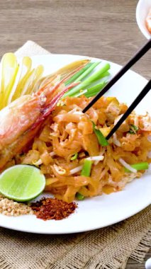 Büyük karidesli Pad Thai, beyaz tabakta servis edilir..