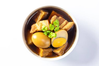 Beyaz arka planda yumurtalı beş baharatlı domuz eti güveci..