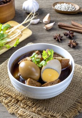 Tahta bir masada yumurtalı beş baharatlı domuz eti güveci..