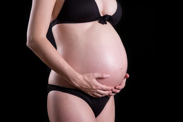 Close up of a cute pregnant belly with black background — Stock Photo, Image