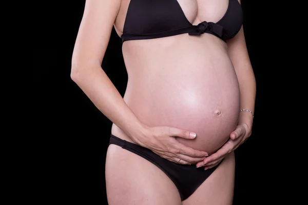 Close up van een schattig zwangere buik met zwarte achtergrond Rechtenvrije Stockfoto's