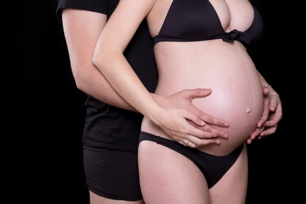 Man handen aanraken van de buik van zijn zwangere vrouw — Stockfoto