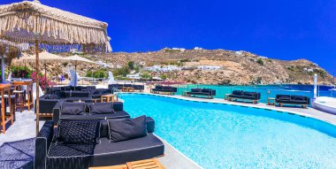 Lüks Yunan bayramları. Büyüleyici Mykonos adası. Yüzme havuzlu bar bölgesi olan ünlü Süper Cennet plajı.
