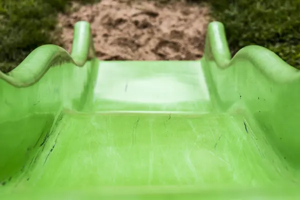 Grüne Kinderrutsche auf Spielplatz — Stockfoto