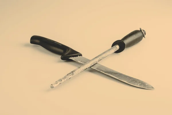 Cuchillo y piedra de afilar aislados sobre fondo blanco — Foto de Stock