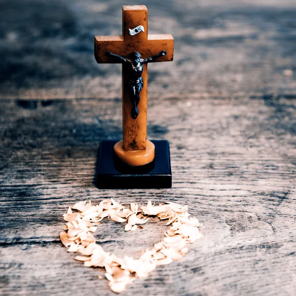 Beautiful old cross with jesus and heart from leafs on the old w — Stock Photo, Image