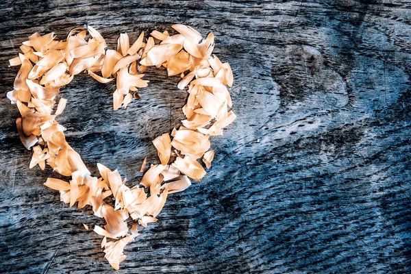 Een hart van bloemblaadjes liggend op een houten tafel — Stockfoto