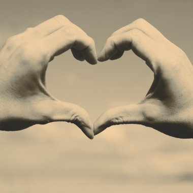 Sarı alan ve mavi gökyüzü kalp şekli el - love