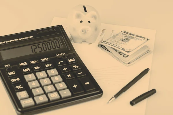 Business Charts with calculator, money, piggy box and pen — Stock Photo, Image
