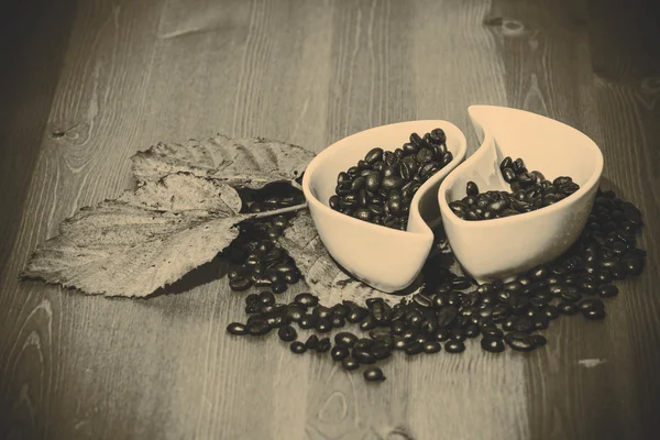 Tazze con chicchi di caffè su un tavolo di legno — Foto Stock