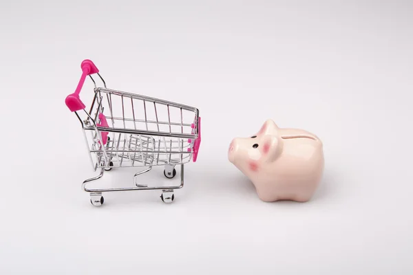 Shopping cart versus pig money box — Stock Photo, Image