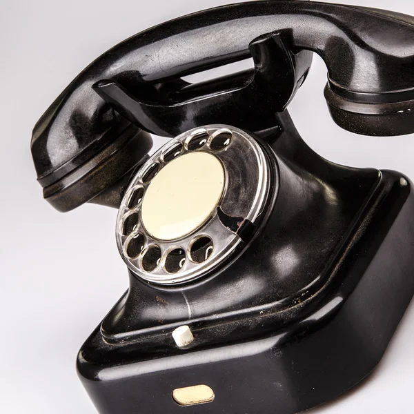 Velho telefone preto com poeira e arranhões no fundo branco — Fotografia de Stock