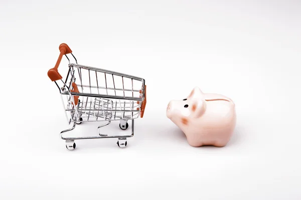 Shopping cart versus pig money box — Stock Photo, Image