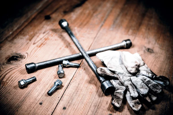 Old used wrench with screw and dirty gloves — Stock Photo, Image