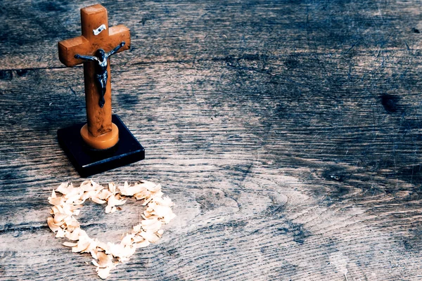 Beautiful old cross with jesus and heart from leafs on the old w — Stock Photo, Image