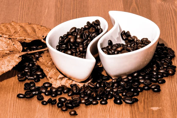 Cups met koffiebonen op een houten tafel — Stockfoto