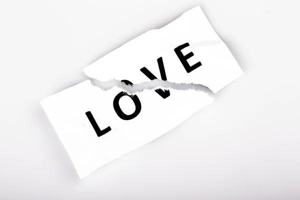 "Love "word written on torn paper — стоковое фото