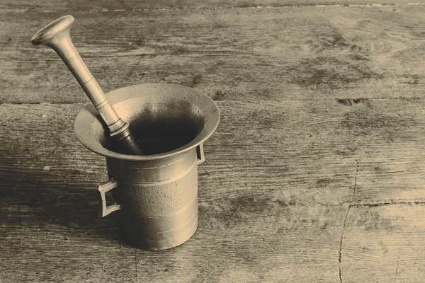 Old bronze mortar with pestle on wootden table — Stock Photo, Image