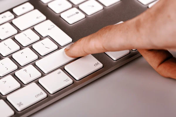 Teclado de plata con dedo de mujer —  Fotos de Stock