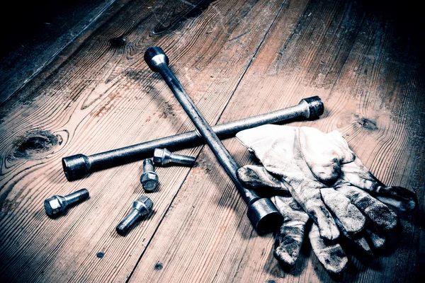 Старый ключ с винтом и грязными перчатками — стоковое фото