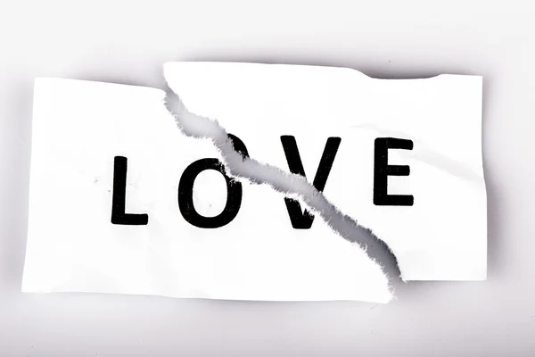 "Love "word written on torn paper — стоковое фото