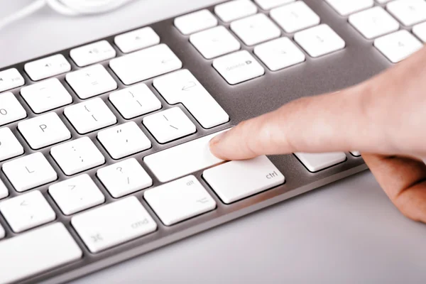 Silver keyboard with woman finger — Stock Photo, Image