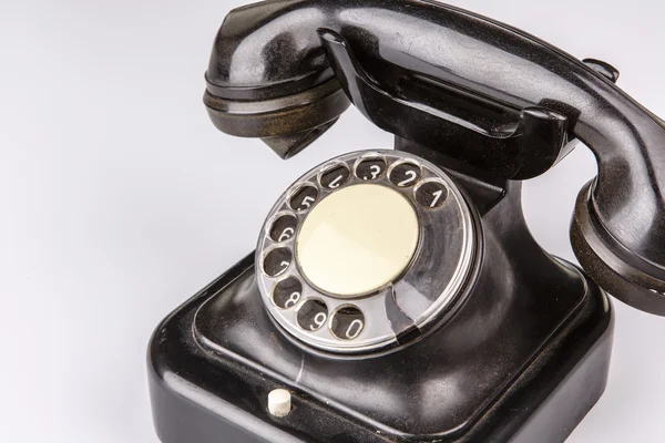 Velho telefone preto com poeira e arranhões no fundo branco — Fotografia de Stock