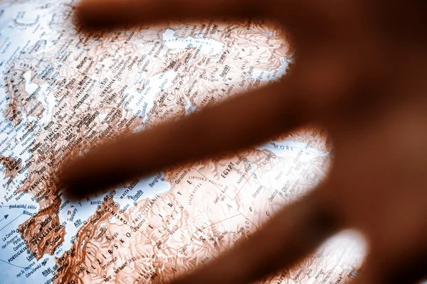 Hand in front of globe — Stock Photo, Image