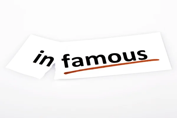 The word infamous changed to famous on torn paper — Stock Photo, Image
