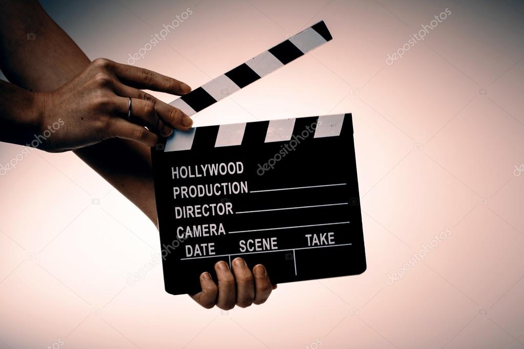 Movie flapper in womans hands on white background