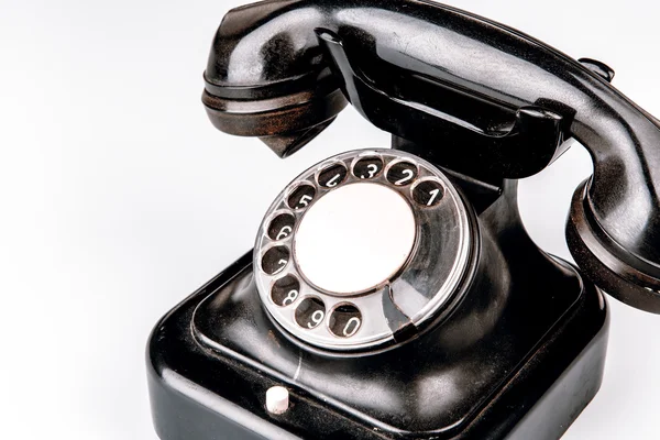 Altes schwarzes Telefon mit Staub und Kratzern auf weißem Hintergrund — Stockfoto