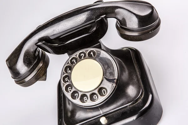 Old black phone with dust and scratches on white background — Stock Photo, Image