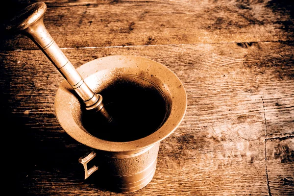 Old bronze mortar with pestle on wootden table — Stock Photo, Image