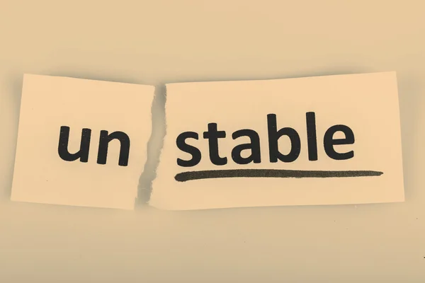 The word unstable changed to stable on torn paper — Stock Photo, Image