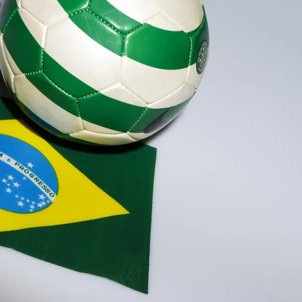 Bola de futebol verde e branco na bandeira do brasil — Fotografia de Stock