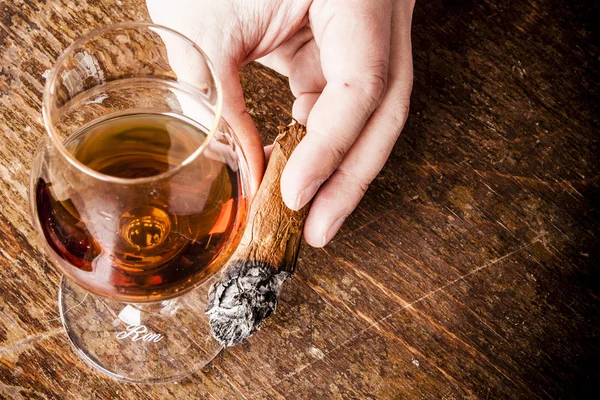 Zigarre in der Hand mit einem Glas Alkohol — Stockfoto