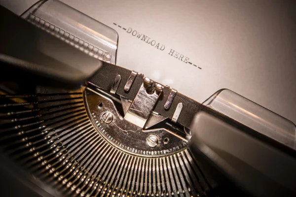 Old typewriter with text download here — Stock Photo, Image