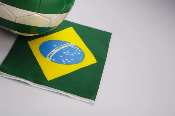 Bola de futebol verde e branco na bandeira do brasil — Fotografia de Stock