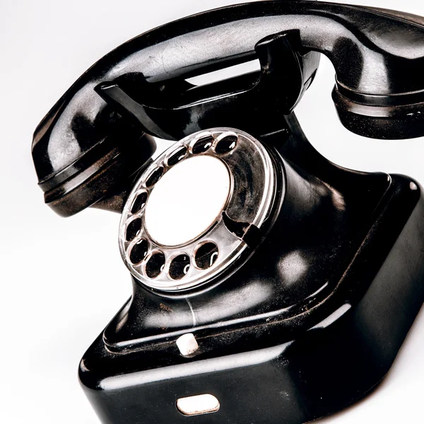 Old black phone with dust and scratches on white background — Stock Photo, Image